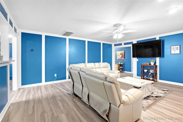 living room featuring visible vents, ceiling fan, baseboards, and wood finished floors