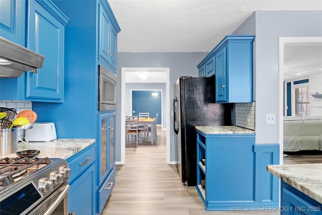 kitchen featuring blue cabinets, under cabinet range hood, light wood-style flooring, and stainless steel appliances