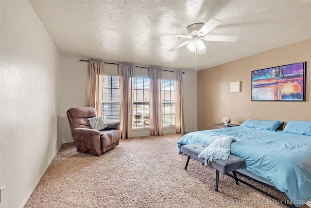 bedroom featuring a ceiling fan, light colored carpet, and a textured wall