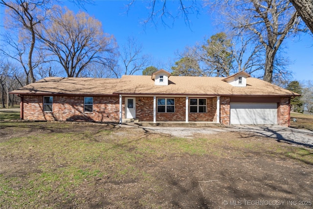 view of front facade featuring a garage, brick siding, and dirt driveway