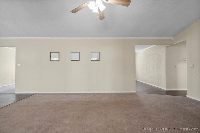 empty room featuring ornamental molding, dark carpet, a textured ceiling, and ceiling fan