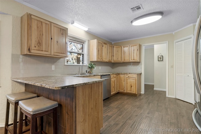 kitchen featuring visible vents, stainless steel dishwasher, dark wood-type flooring, a peninsula, and a kitchen breakfast bar