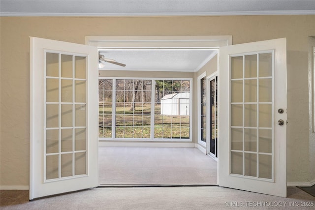 doorway featuring a textured ceiling, french doors, ornamental molding, and carpet flooring