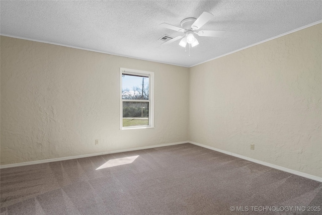 spare room with ornamental molding, visible vents, a textured wall, and carpet flooring