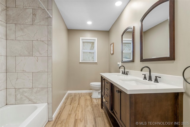 full bath featuring wood finished floors, a sink, toilet, and baseboards