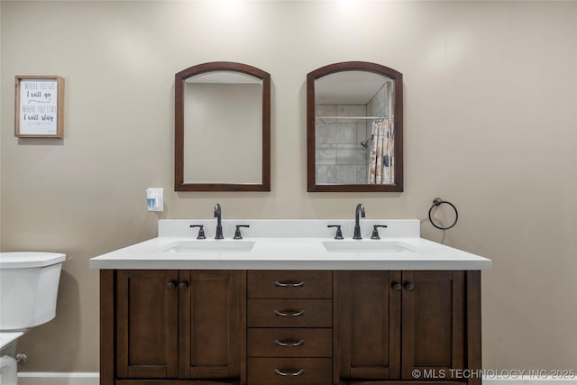 bathroom featuring a sink, toilet, and double vanity