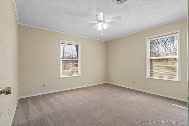 empty room with a textured ceiling, a textured wall, visible vents, ornamental molding, and carpet