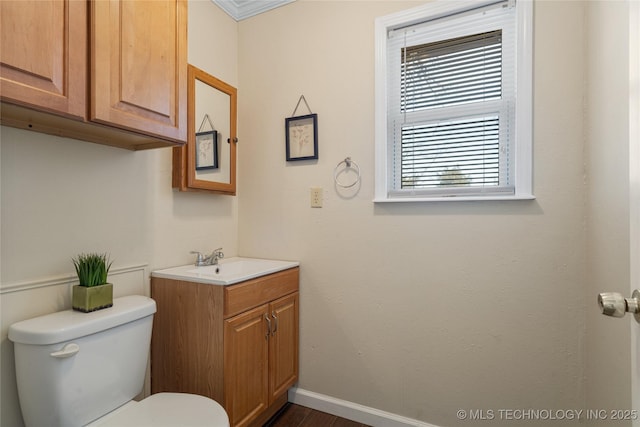 bathroom with toilet, baseboards, and vanity