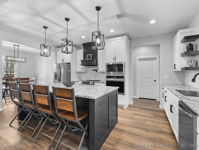 kitchen featuring open shelves, white cabinetry, stainless steel appliances, and a sink