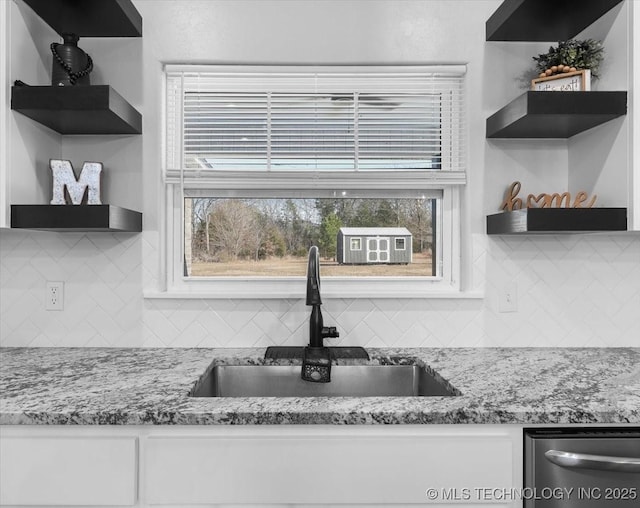 kitchen with white cabinetry, a sink, and open shelves