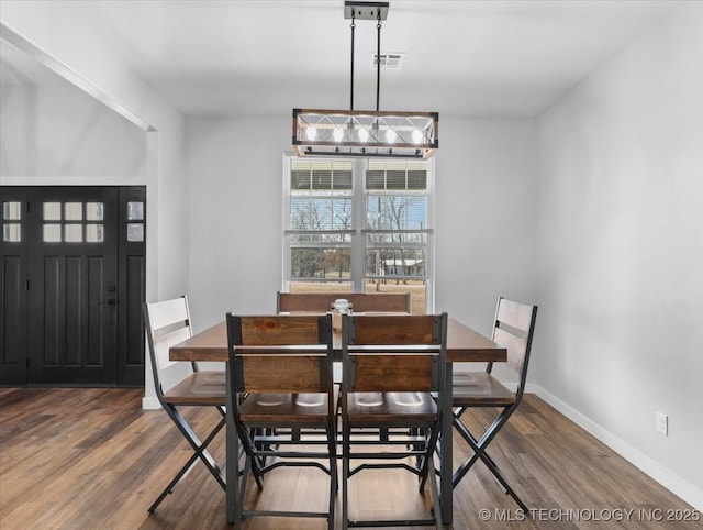 dining area with visible vents, baseboards, and wood finished floors