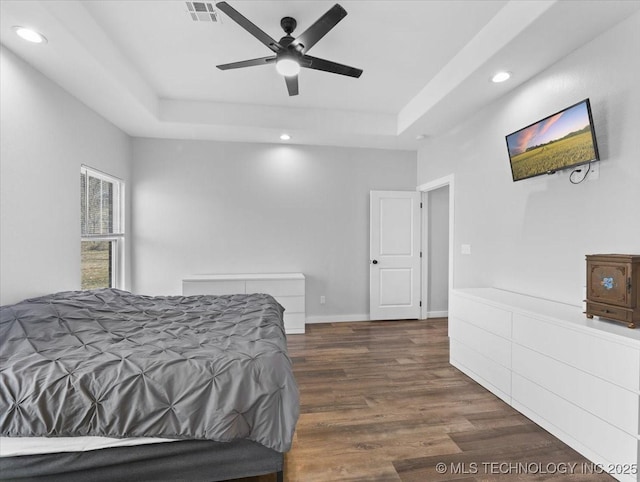 bedroom with recessed lighting, a raised ceiling, visible vents, dark wood-type flooring, and ceiling fan