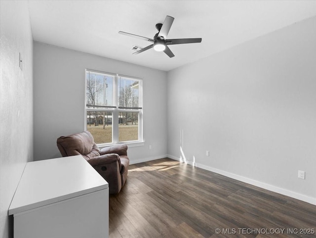 sitting room with ceiling fan, visible vents, baseboards, and dark wood finished floors