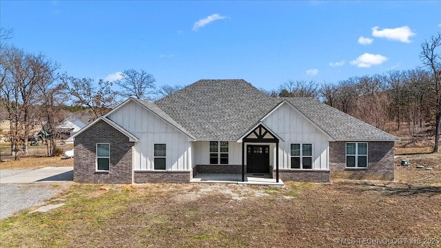 modern farmhouse with board and batten siding, brick siding, and roof with shingles