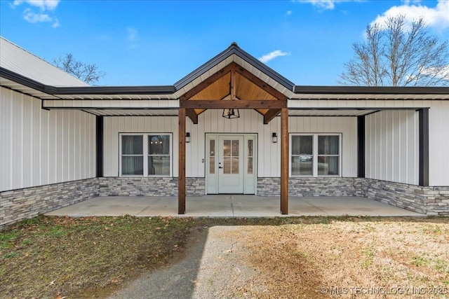 property entrance with stone siding, a patio, and french doors