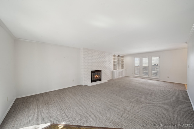 unfurnished living room featuring built in shelves, baseboards, a fireplace, crown molding, and carpet flooring