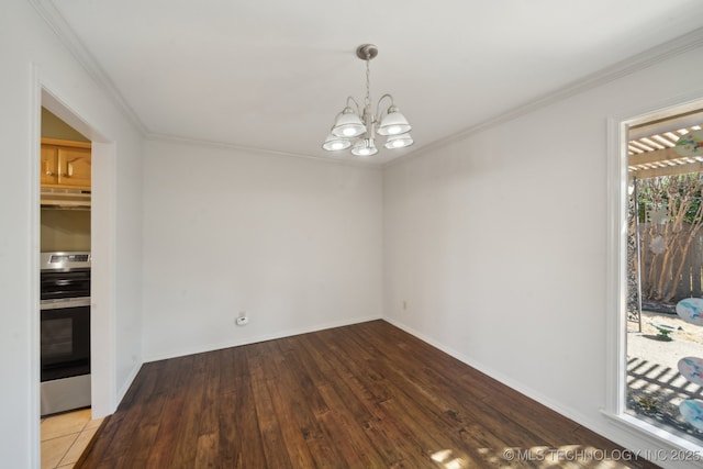 spare room featuring a notable chandelier, wood finished floors, baseboards, and ornamental molding