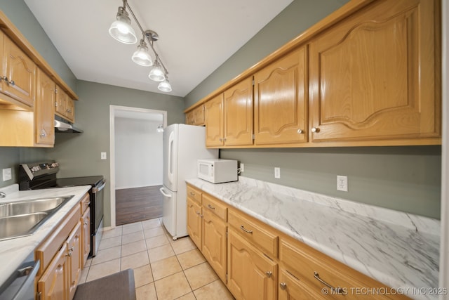 kitchen with under cabinet range hood, stainless steel appliances, a sink, and light tile patterned floors