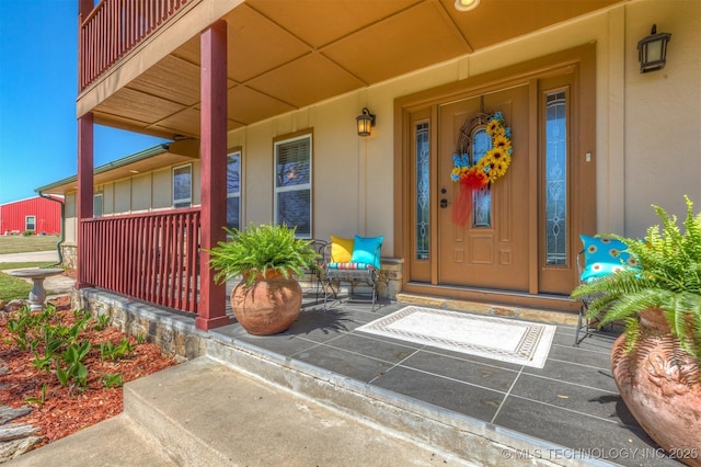 view of exterior entry featuring a porch and board and batten siding