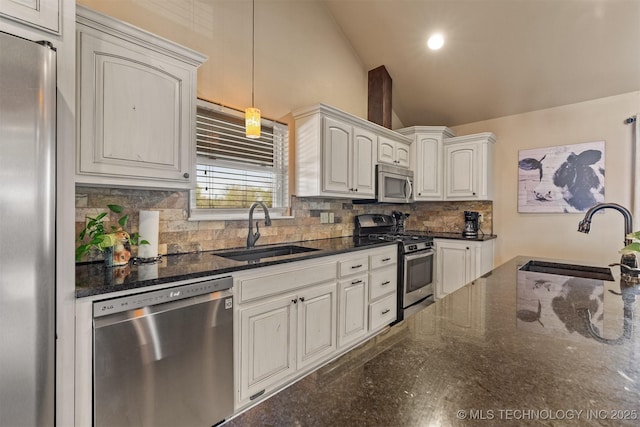 kitchen with lofted ceiling, decorative backsplash, stainless steel appliances, and a sink