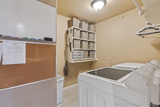 laundry area with laundry area, baseboards, and washer and clothes dryer