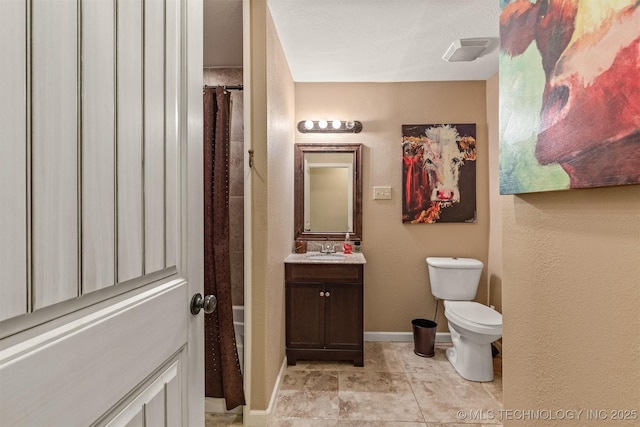 bathroom featuring toilet, baseboards, and vanity