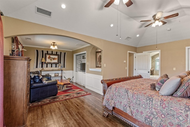 bedroom with vaulted ceiling, arched walkways, wood finished floors, and visible vents