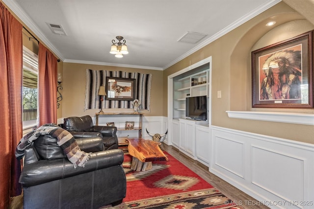 living room with built in features, visible vents, ornamental molding, and dark wood-type flooring