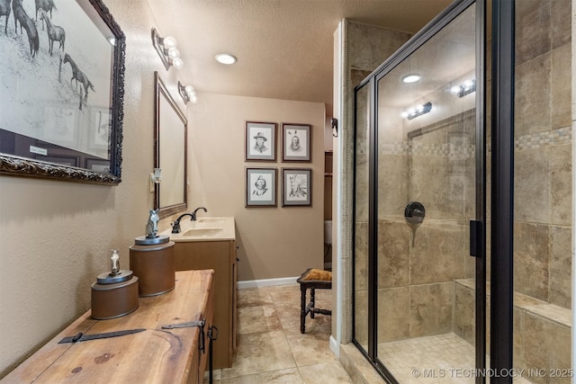 bathroom featuring toilet, a shower stall, vanity, and baseboards