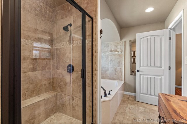 bathroom with a shower stall, baseboards, and a bath