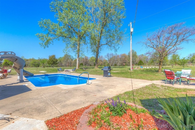 pool with a yard, a grill, a diving board, and a patio