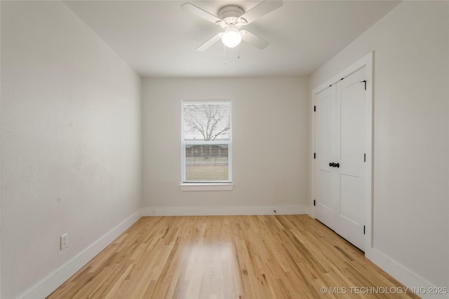 unfurnished bedroom with ceiling fan, light wood-style flooring, and baseboards