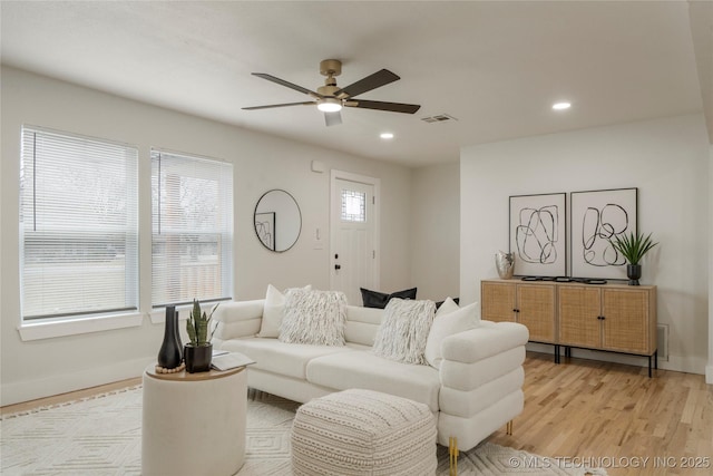 living room with light wood-style flooring, visible vents, a wealth of natural light, and recessed lighting