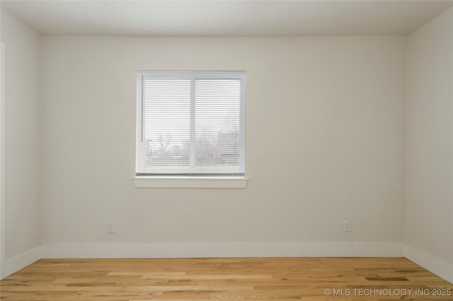 unfurnished room featuring wood finished floors and baseboards