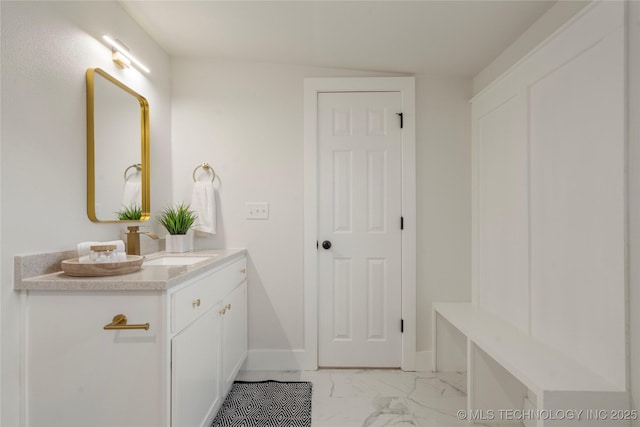 bathroom featuring marble finish floor, vanity, and baseboards