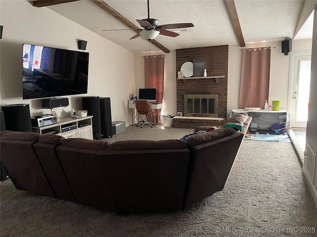 living room featuring ceiling fan, a textured ceiling, vaulted ceiling with beams, a fireplace, and carpet