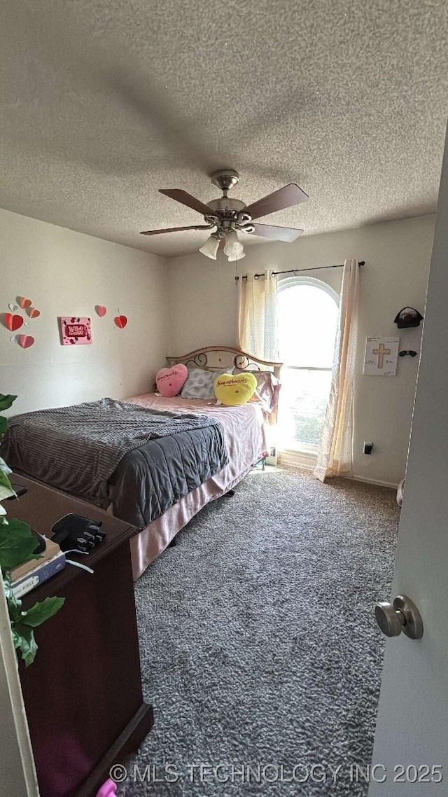 bedroom featuring carpet flooring, ceiling fan, and a textured ceiling