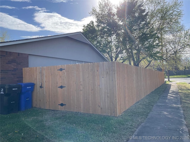 view of side of home with brick siding and fence