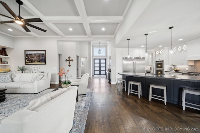 living room with beam ceiling, dark wood-style flooring, recessed lighting, coffered ceiling, and baseboards