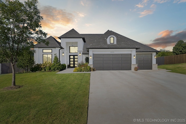 view of front facade featuring a garage, driveway, roof with shingles, fence, and a yard