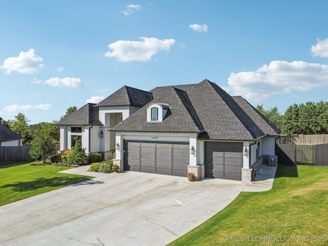 french provincial home featuring roof with shingles, fence, a garage, driveway, and a front lawn