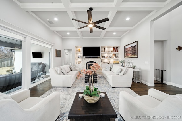 living room with coffered ceiling, a fireplace, wood finished floors, baseboards, and beamed ceiling