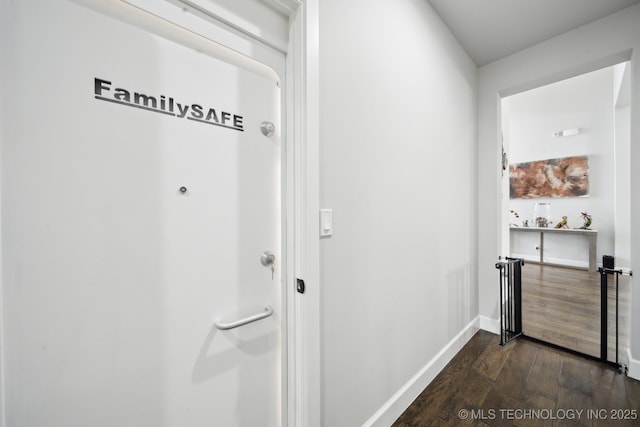 corridor with baseboards and dark wood finished floors