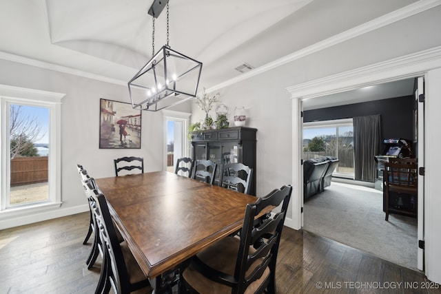 dining space featuring dark wood-style flooring, crown molding, and baseboards