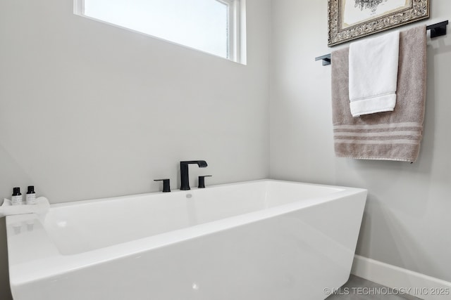 full bathroom with baseboards and a freestanding bath