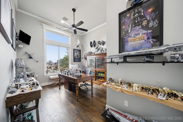 home office featuring a ceiling fan, baseboards, visible vents, dark wood finished floors, and crown molding