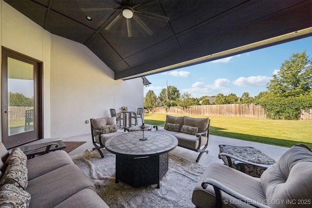 view of patio / terrace with a ceiling fan, fence, and an outdoor living space