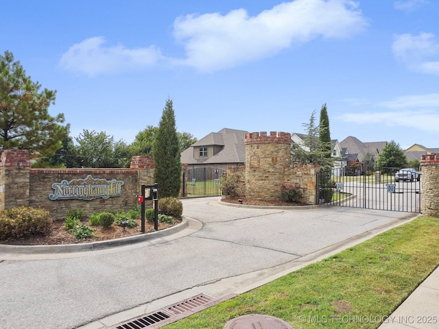 view of road featuring a gate, curbs, and a gated entry