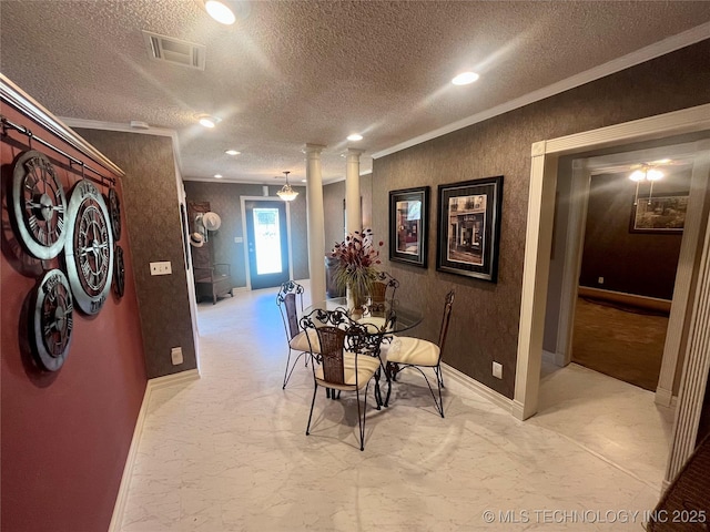 dining room with decorative columns, visible vents, ornamental molding, a textured ceiling, and baseboards