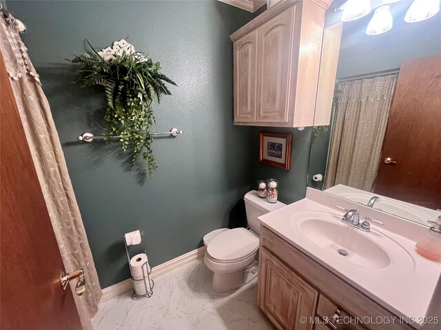 bathroom with marble finish floor, toilet, vanity, and baseboards